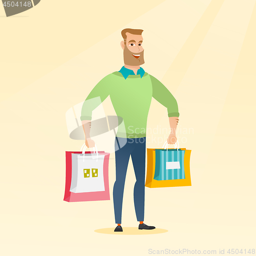 Image of Young happy caucasian man with shopping bags.