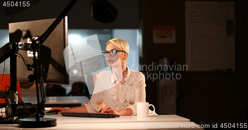 Image of woman working on computer in dark office