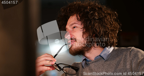 Image of man working on computer in dark office