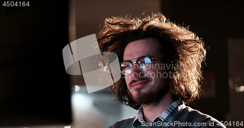 Image of man working on computer in dark office