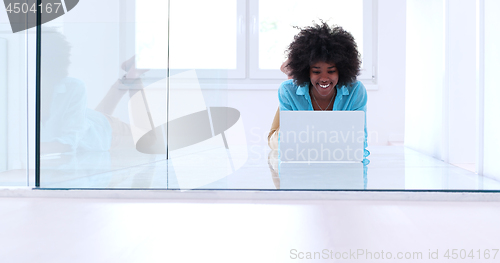 Image of black women using laptop computer on the floor