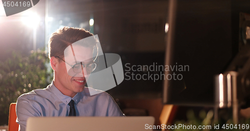 Image of man working on computer in dark office