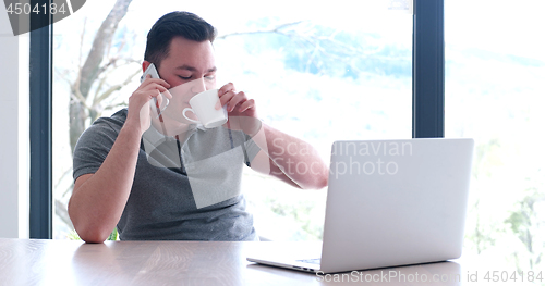 Image of businessman working using a laptop in startup office