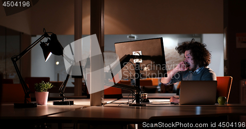 Image of man working on computer in dark office