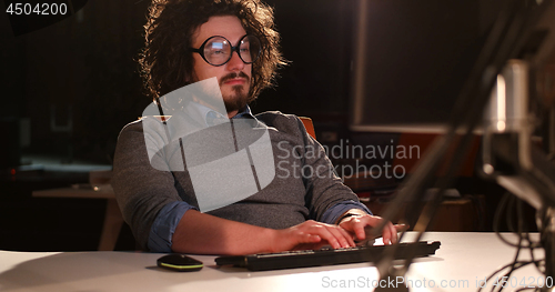 Image of man working on computer in dark office