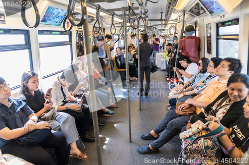 Image of Passenegers using their mobile phone devices while commuting by city metro in Bangkok, Thailand