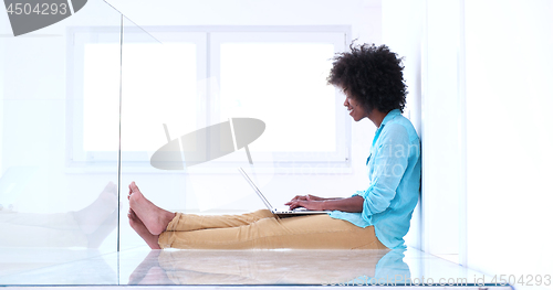 Image of black women using laptop computer on the floor