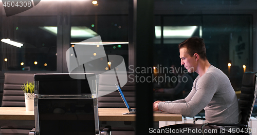 Image of man working on laptop in dark office