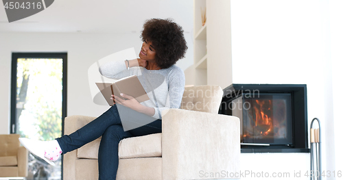 Image of black woman at home reading book