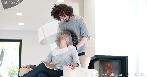 Image of multiethnic couple hugging in front of fireplace