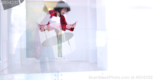 Image of young man using a tablet at home