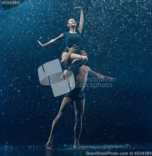 Image of Young couple of ballet dancers dancing unde rwater drops