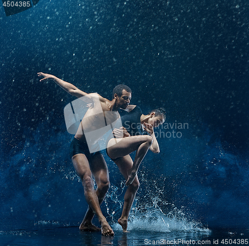 Image of Young couple of ballet dancers dancing unde rwater drops