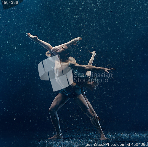 Image of Young couple of ballet dancers dancing unde rwater drops