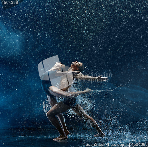 Image of Young couple of ballet dancers dancing unde rwater drops