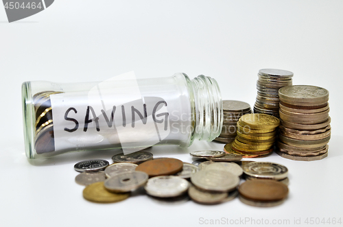 Image of Saving lable in a glass jar with coins spilling out