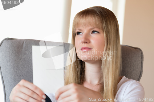 Image of Sad girl holding photo