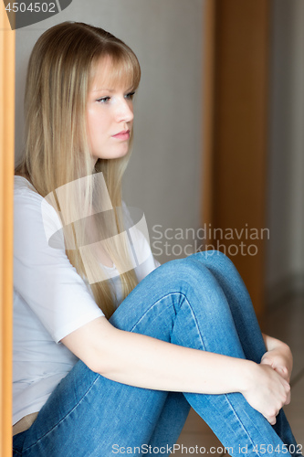 Image of Sad girl is sitting on the floor