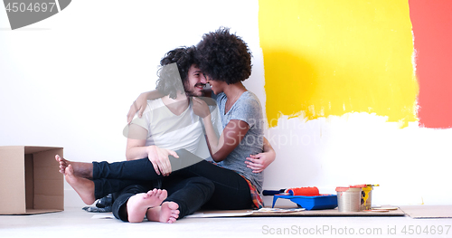 Image of young multiethnic couple relaxing after painting