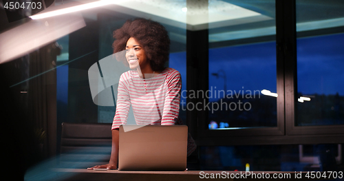 Image of black businesswoman using a laptop in night startup office