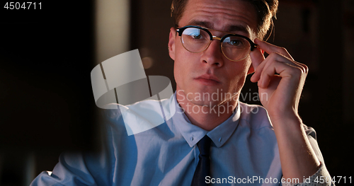 Image of man working on computer in dark office