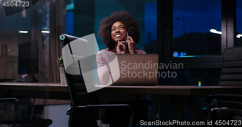Image of black businesswoman using a laptop in night startup office