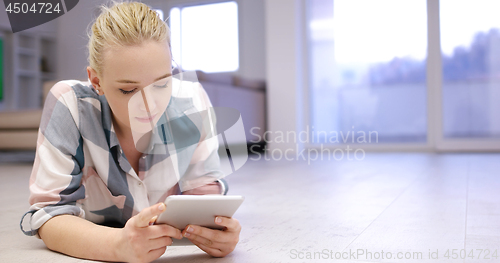 Image of young women using tablet computer on the floor