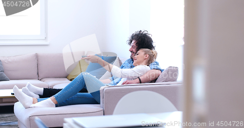 Image of Young couple on the sofa watching television