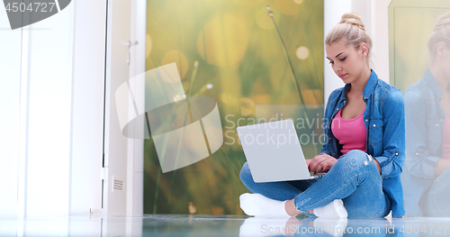 Image of young women using laptop computer on the floor