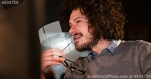 Image of man working on computer in dark office