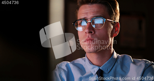 Image of man working on computer in dark office