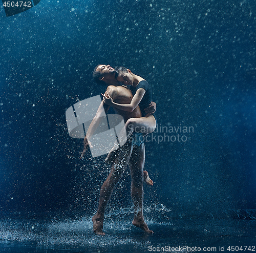 Image of Young couple of ballet dancers dancing unde rwater drops