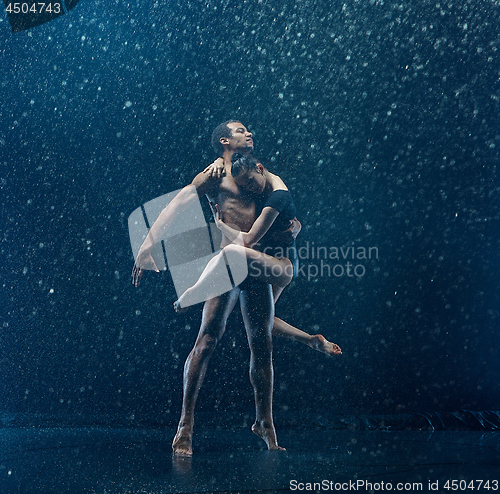 Image of Young couple of ballet dancers dancing unde rwater drops