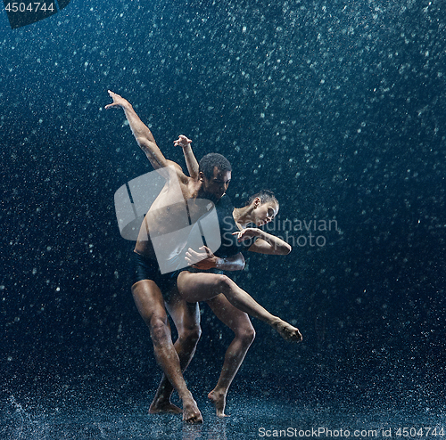 Image of Young couple of ballet dancers dancing unde rwater drops