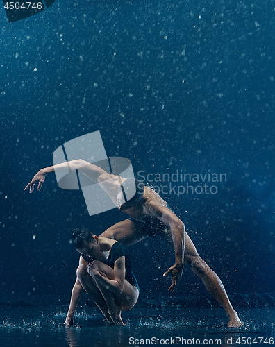 Image of Young couple of ballet dancers dancing unde rwater drops