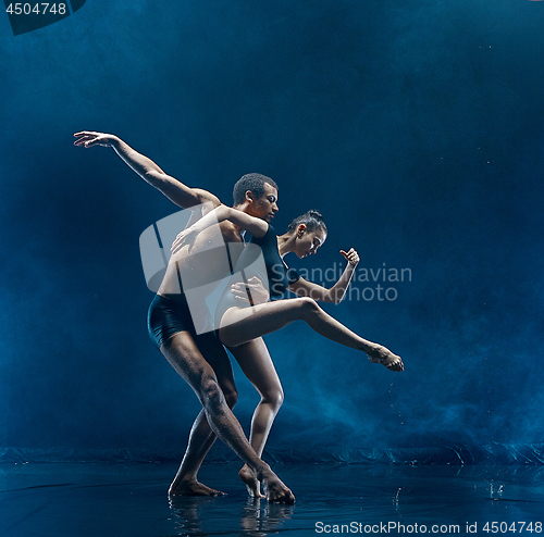Image of Young couple of ballet dancers dancing unde rwater drops
