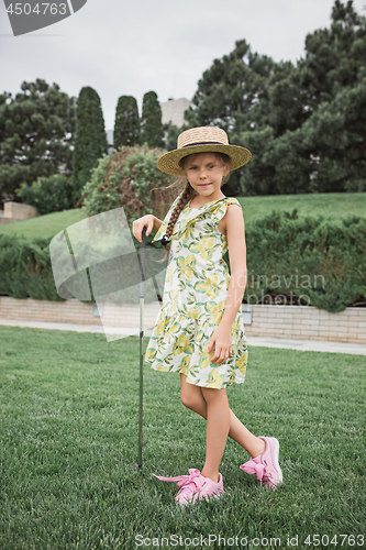 Image of Little girl just swing golf ball on golf course fairway