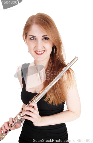 Image of Woman standing, holding her flute and smiling