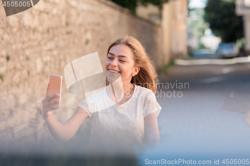 Image of Girl take selfie from hands with phone on summer city