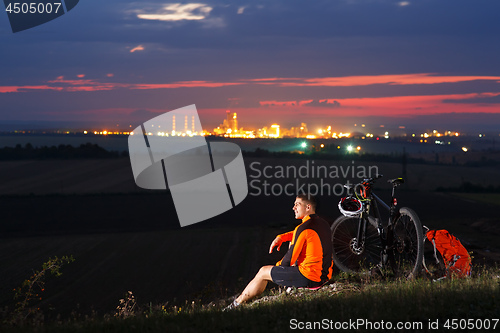 Image of guy has a rest sitting near his bike