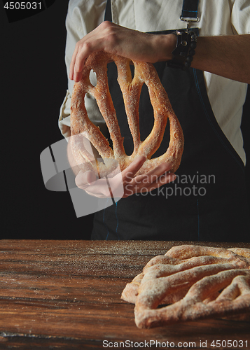 Image of Baker\'s hands hold fougas bread