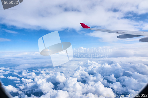 Image of Clouds and sky as seen through window of an aircraft