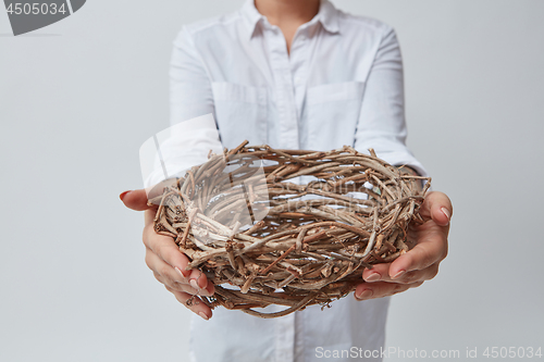 Image of Girl gives a nest of twigs