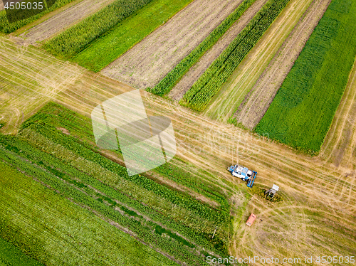 Image of Aerial view frome a drone of combine plowing the ground after harvesting on the field in the autumn time.