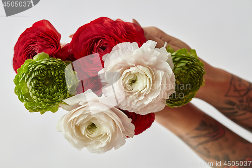 Image of girl with a tattoo on her hands holding a bouquet of flowers