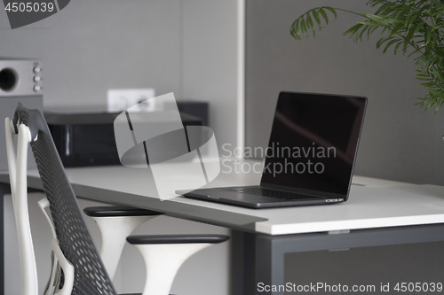 Image of Home office with up-to-date equipment for a comfortable work. New modern notebook, up-to-date equipment on a table.