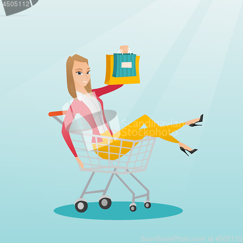 Image of Young caucasian woman riding in shopping trolley.