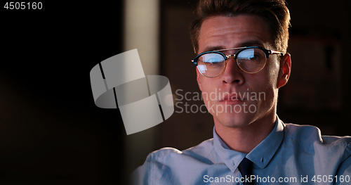 Image of man working on computer in dark office