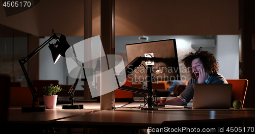 Image of man working on computer in dark office