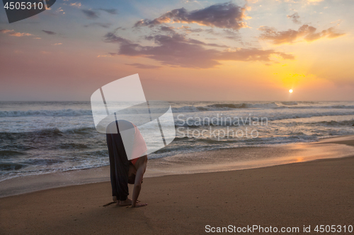 Image of Young sporty fit woman doing yoga Sun salutation Surya Namaskar 